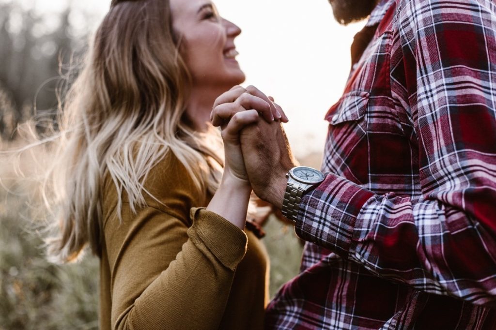 man and woman holding hands while staring at each other