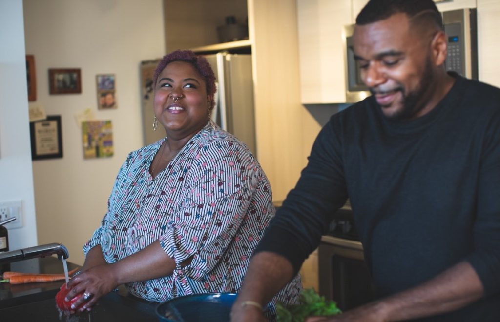 man and woman in the kitchen smiling