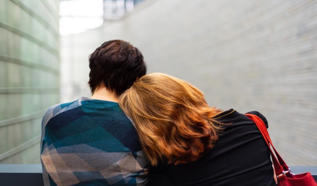 woman laying her head down on a man's shoulder