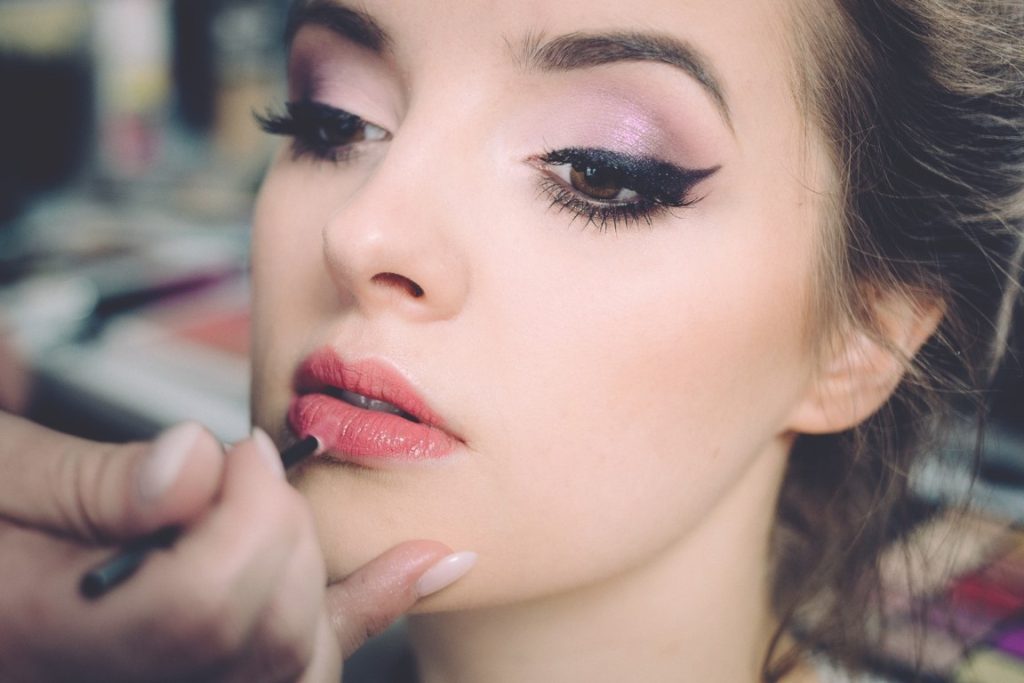 artist putting on make-up on a woman