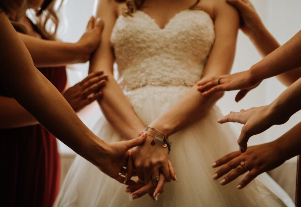 bride being touched by her friends