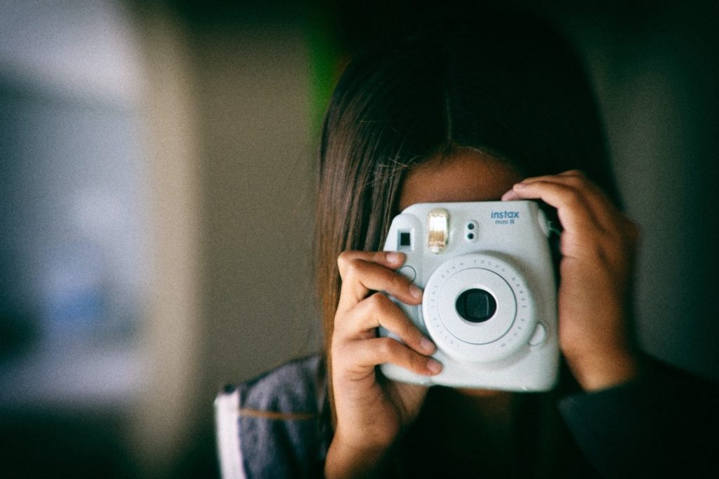 girl taking a polaroid picture