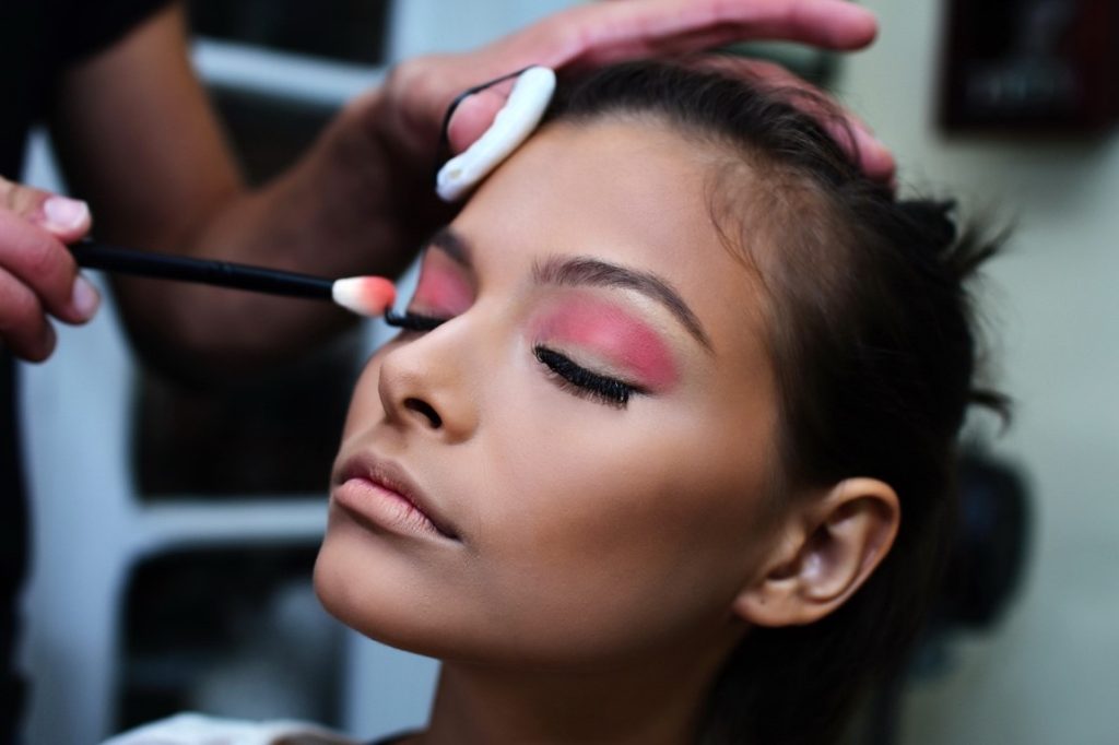 make up artist putting on make up on a woman