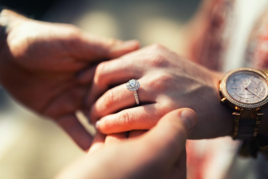 man holding a woman's hand with a ring