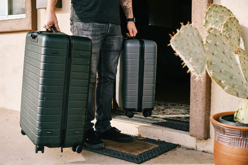 man holding two suitcase
