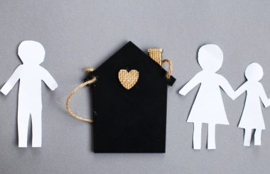 Paper chain cut family near toy house on gray background. Divorce and broken family concept