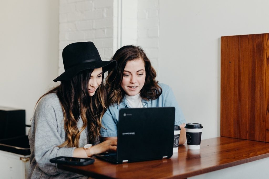 two woman looking at a laptop