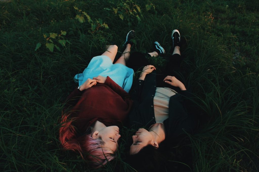 two woman on the grass looking intensely at each other