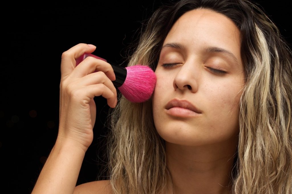 woman putting on her own makeup