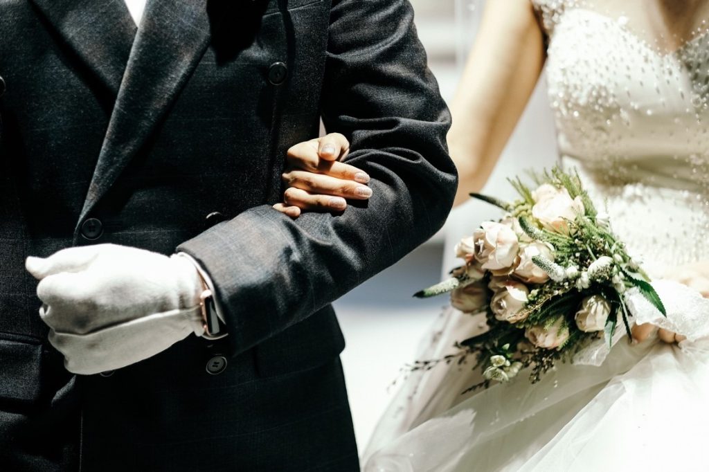 bride clinging to the groom's elbow