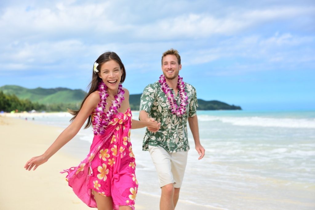 couple wearing Hawaiian clothes at the beach