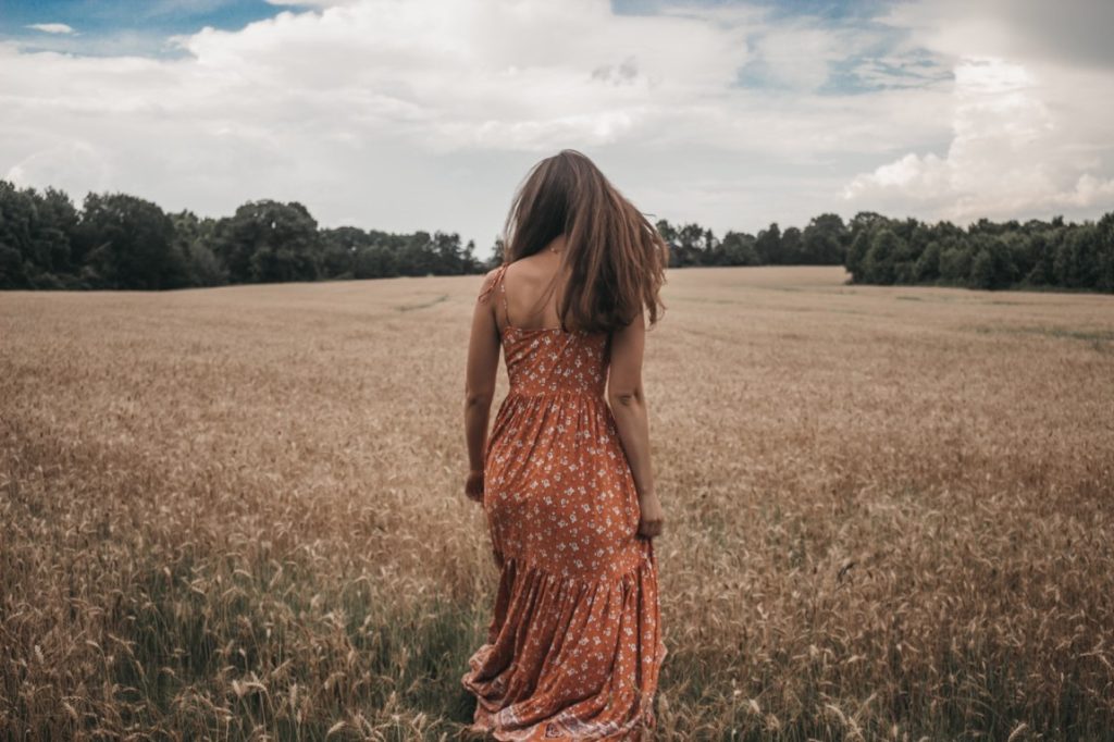 girl at the beach walking at a meadow