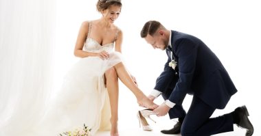 groom taking off bride's shoes