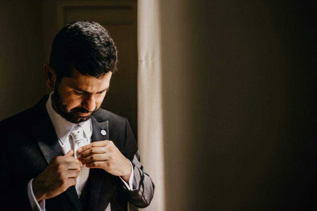 man fixing his tie