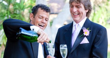 man pouring champagne into his friend's glass