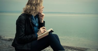 woman writing by the sea