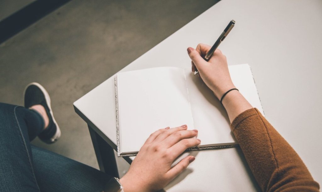 woman writing on her notebook