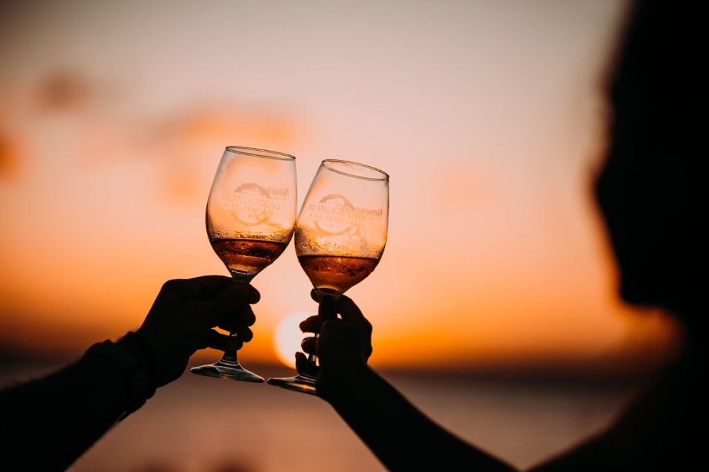 bride and groom clinking wine glasses