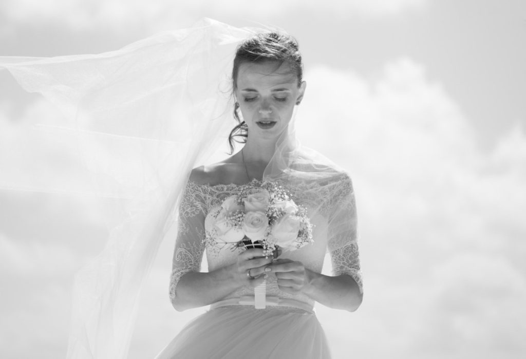 bride looking down and holding a flower