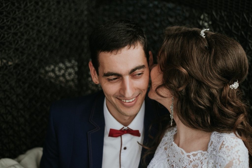 bride whispering something at her new husband