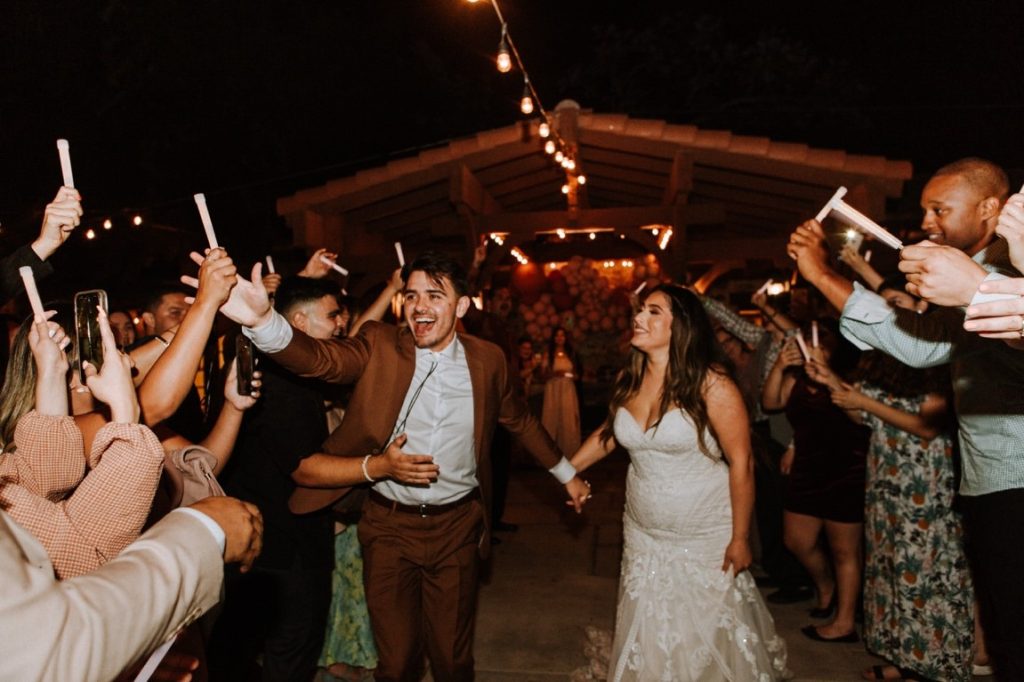 guests welcoming newlyweds with lightsticks