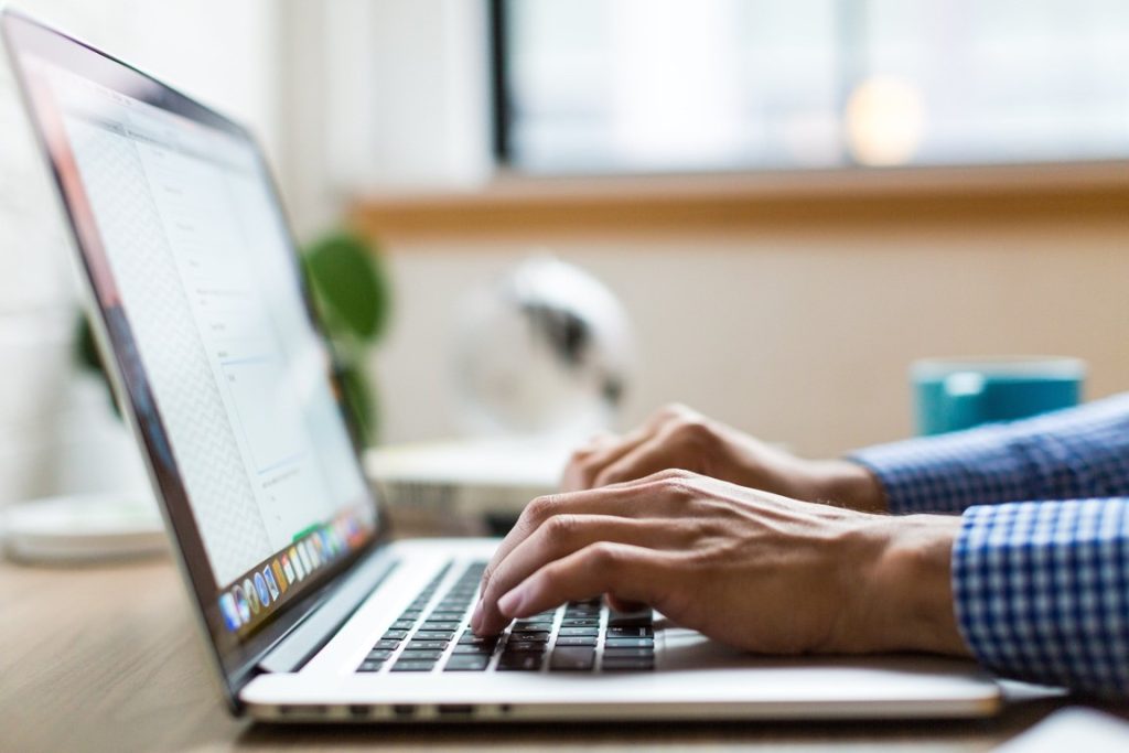 man filling up a form on his laptop