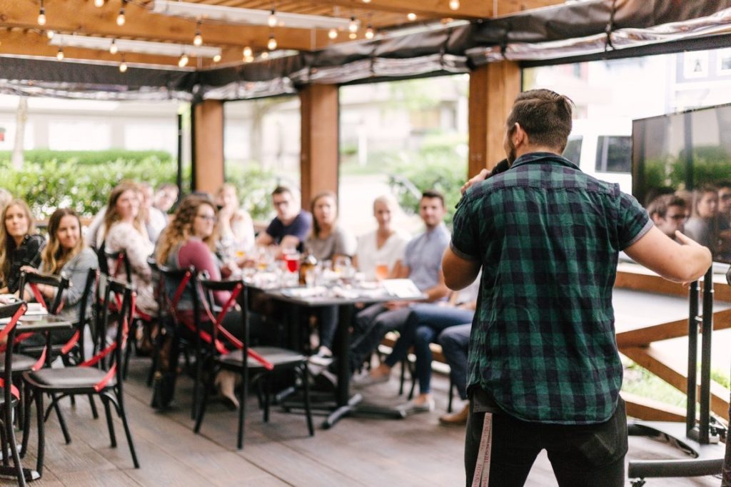 man speaking in front of a crowd