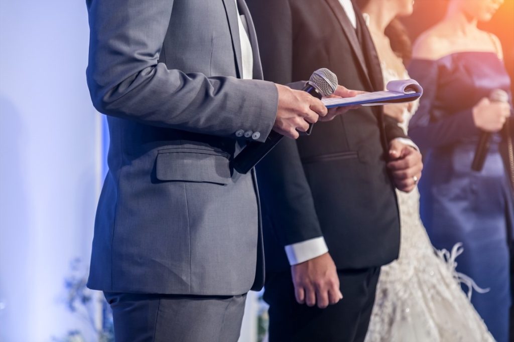 master of ceremonies holding a mike and paper