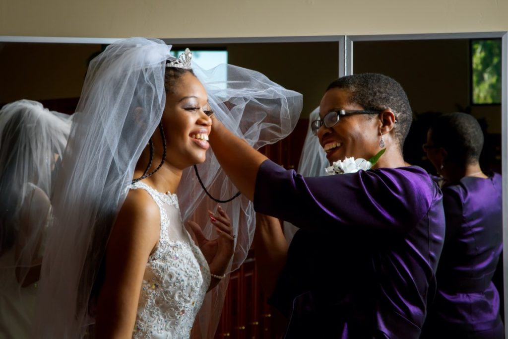 mother helping her daughter prepare for wedding