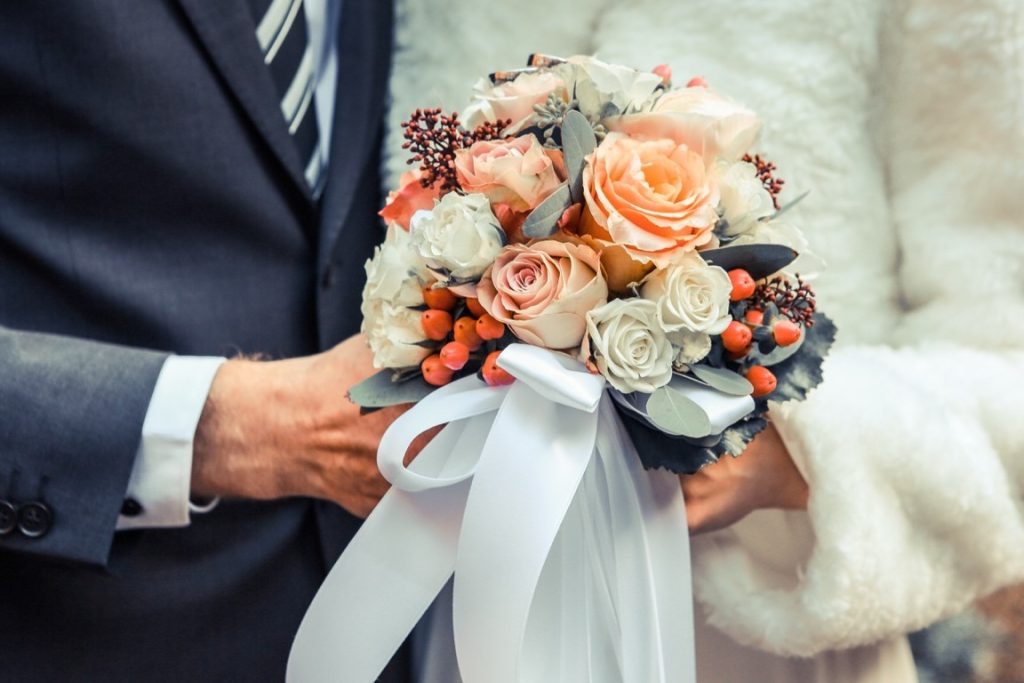 newlywed holding a peach bouquet