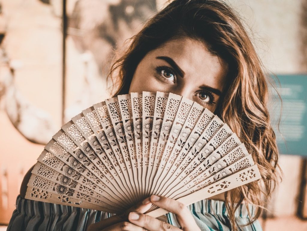 woman holding a wooded fan