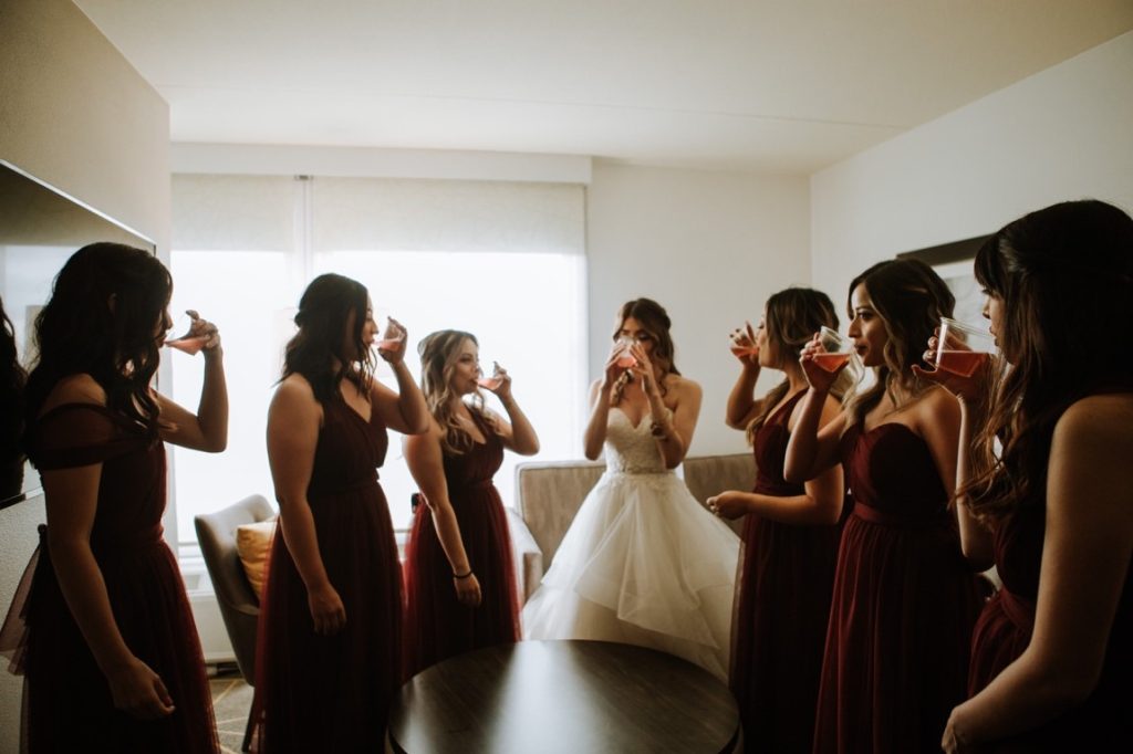 bride and her bridesmaids drinking red wine