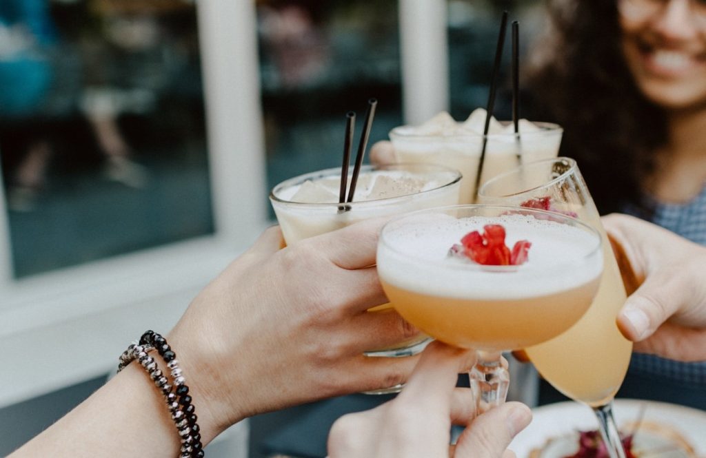 friends clinking cocktail filled glasses