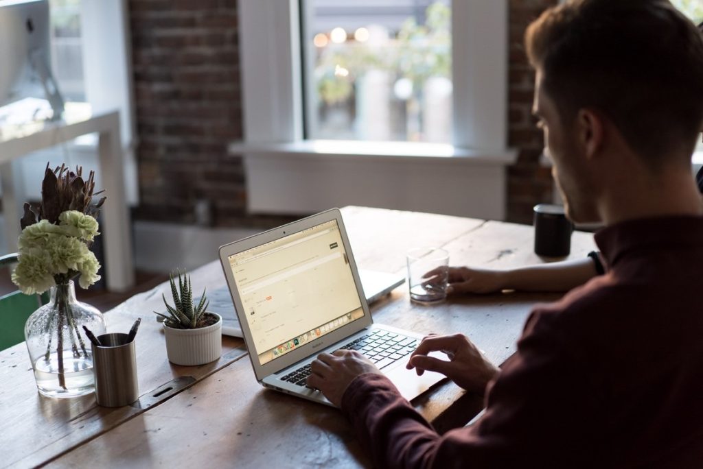 man at a cafe using his laptop