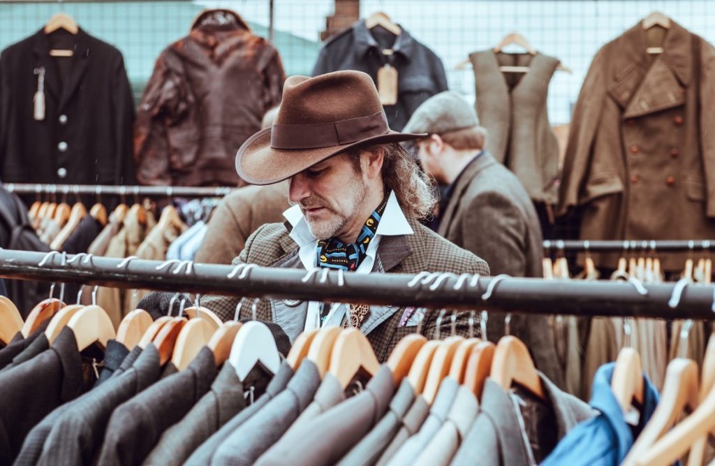 man sifting through the coat section