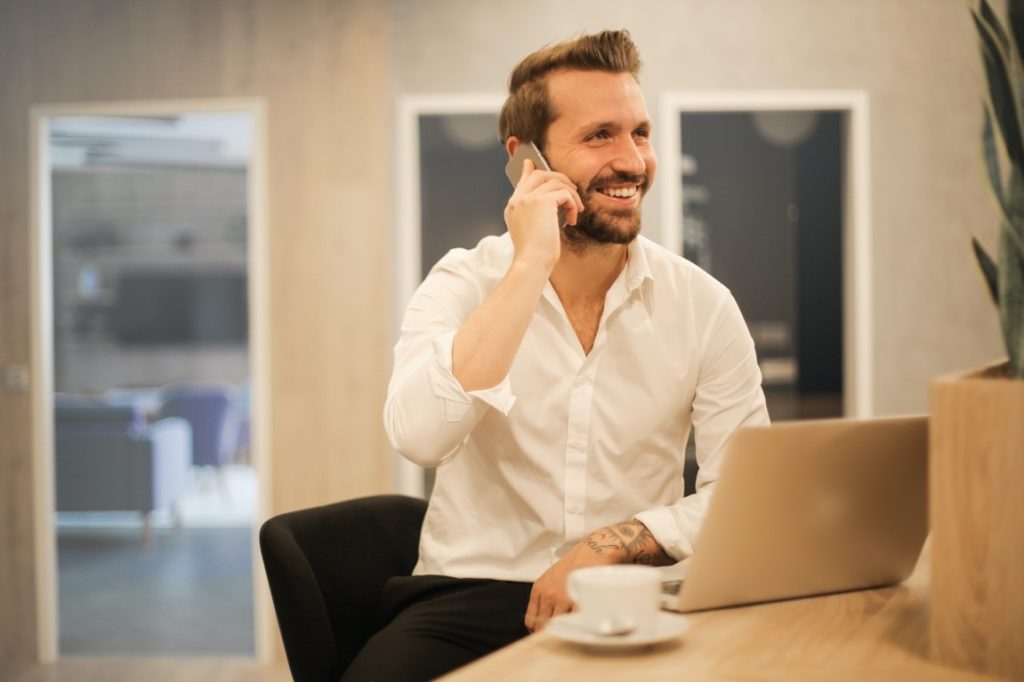 man smiling while on the phone