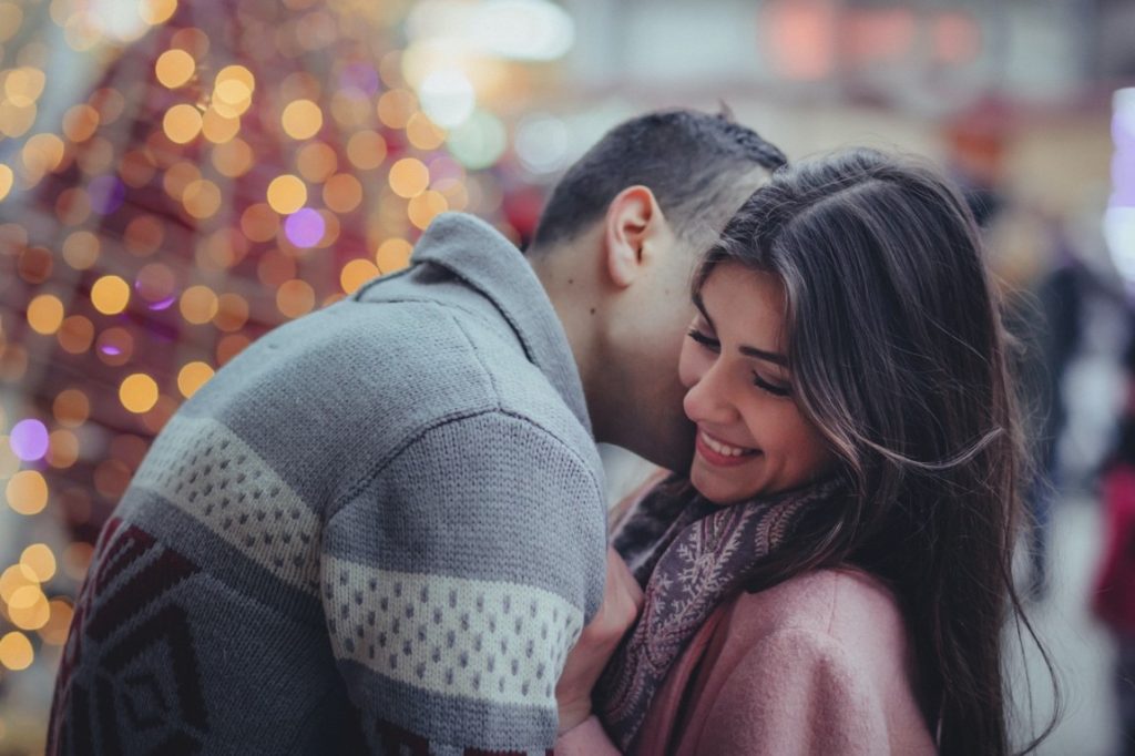 man whispering on a woman