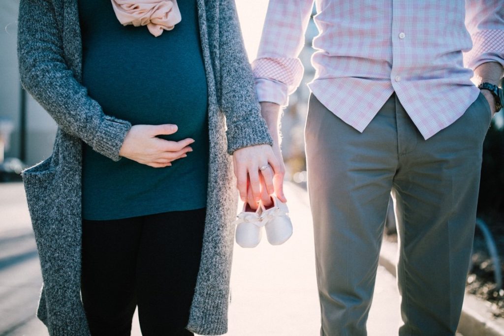 pregnant woman holding hands with husband