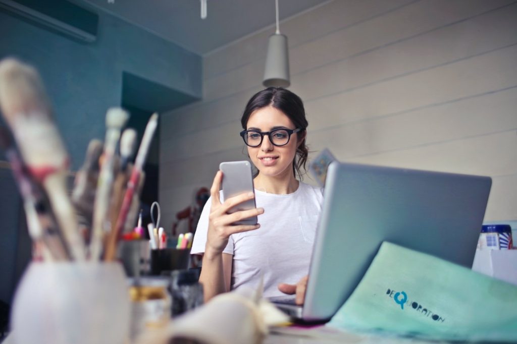 woman in glasses looking at her phone