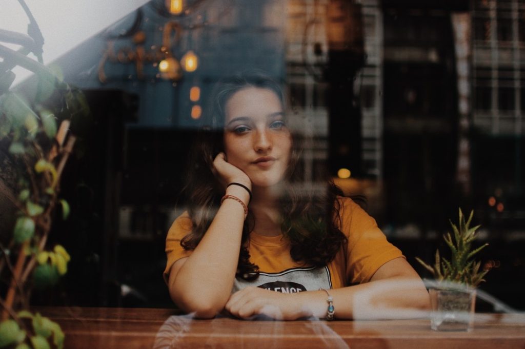 woman sitting behind glass