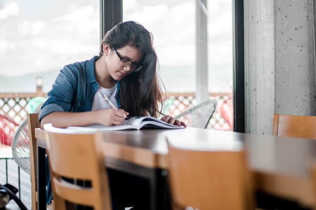 woman writing on a book