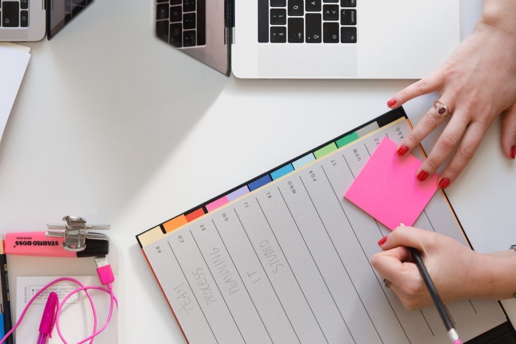 woman writing on sticky note