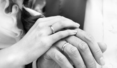 hands of bride and groom wearing wedding band