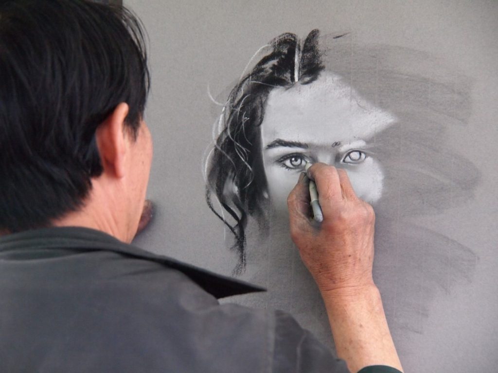 man drawing realistic portrait