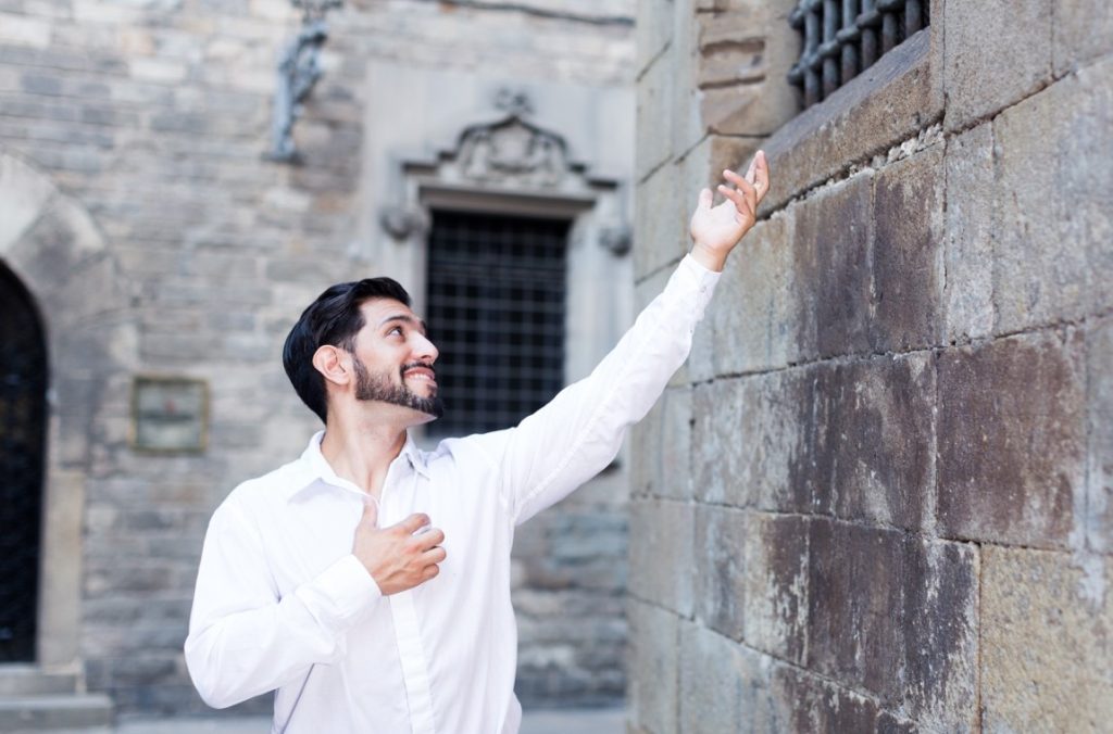 man holding his hand out to the window