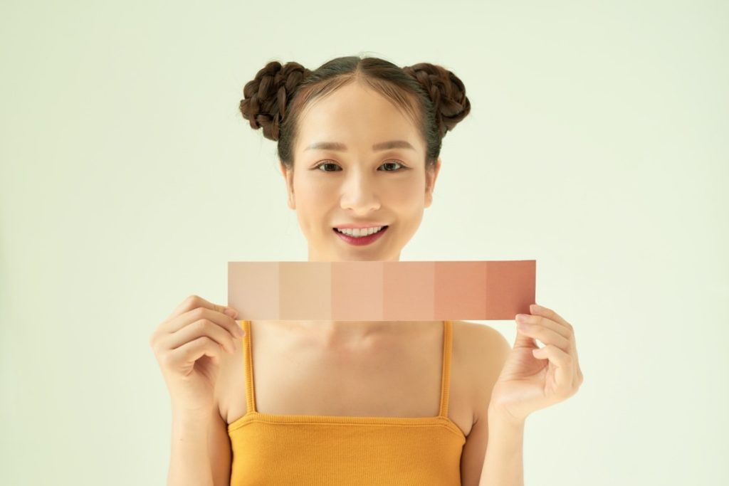 woman holding paper with different skin tones