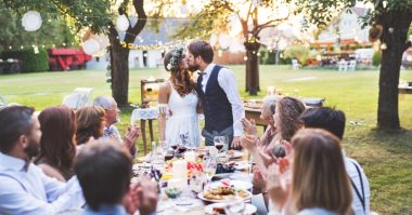bride and groom kissing in front of guests