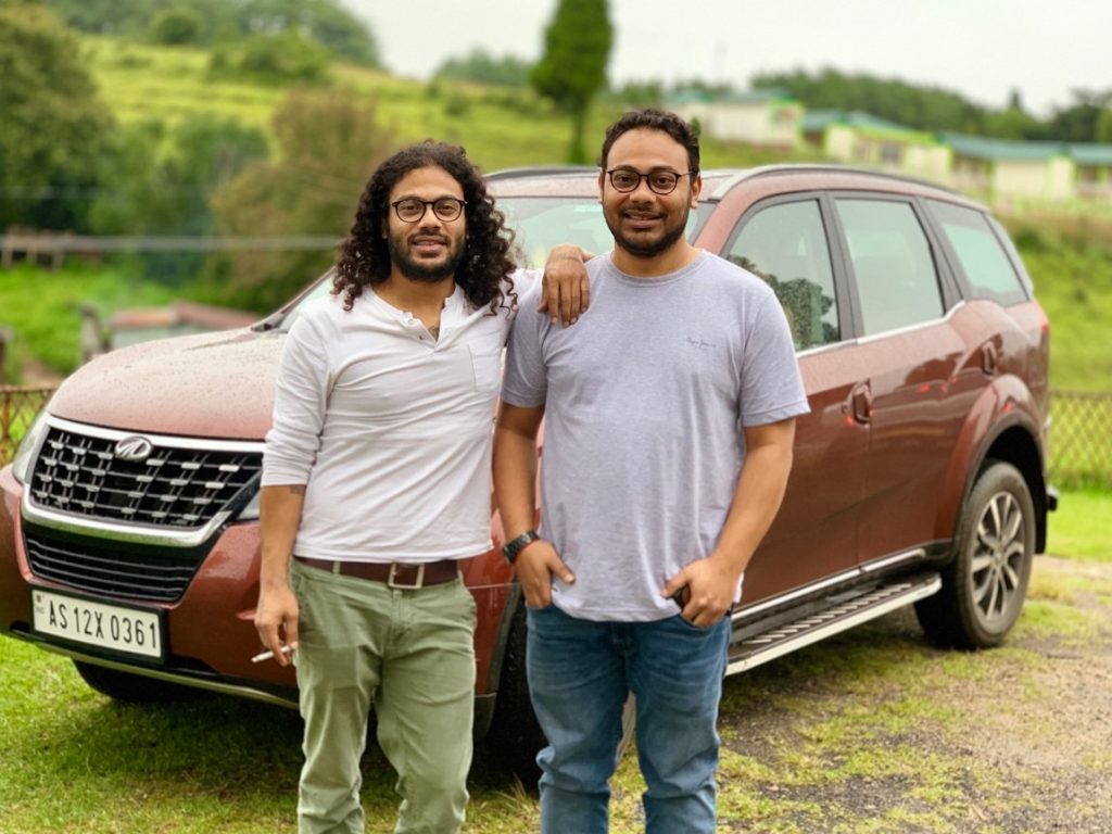 brothers standing in front of a car