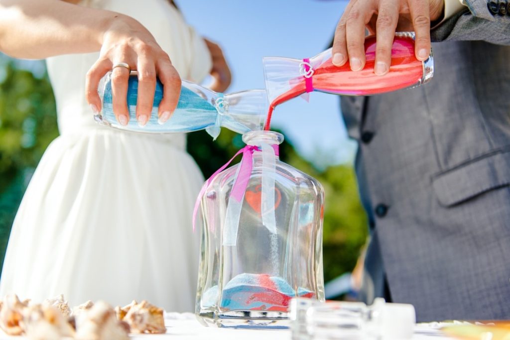 couple pouring sand on a bottle