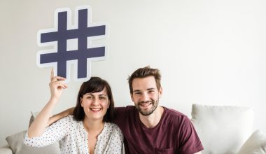 man and woman holding a hashtag sign